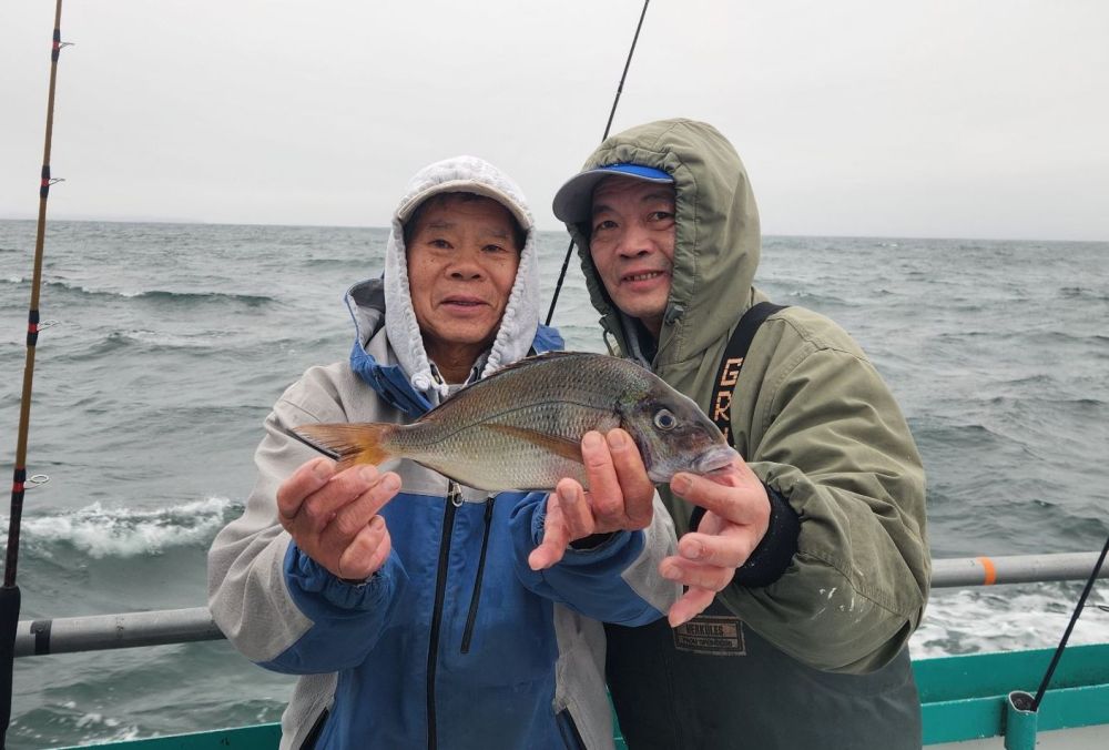 a person holding a fish on a boat in a body of water