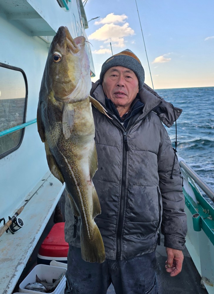 a man holding a fish on a boat