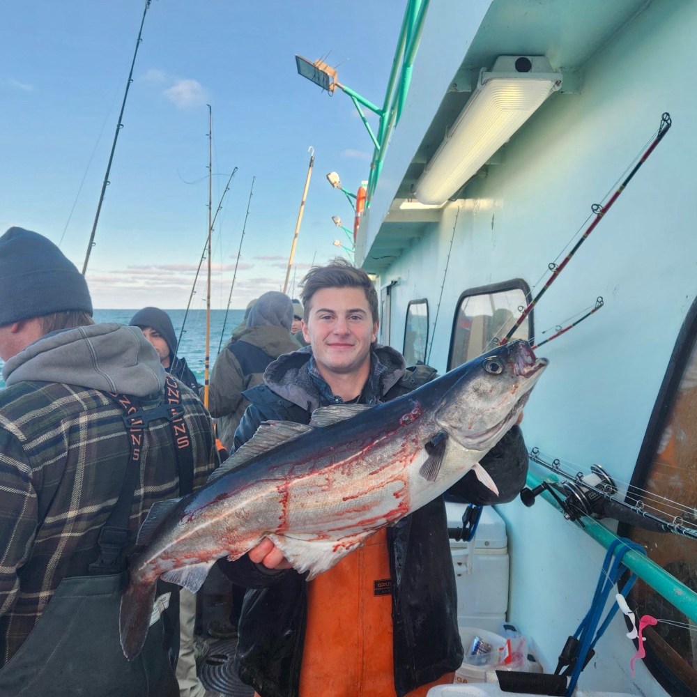 a man holding a fish on a boat