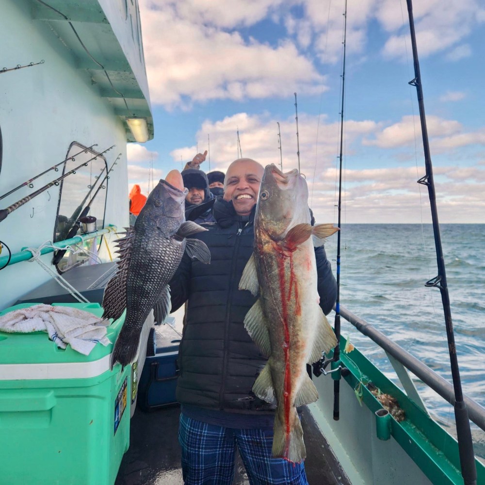 a man holding a fish on a boat