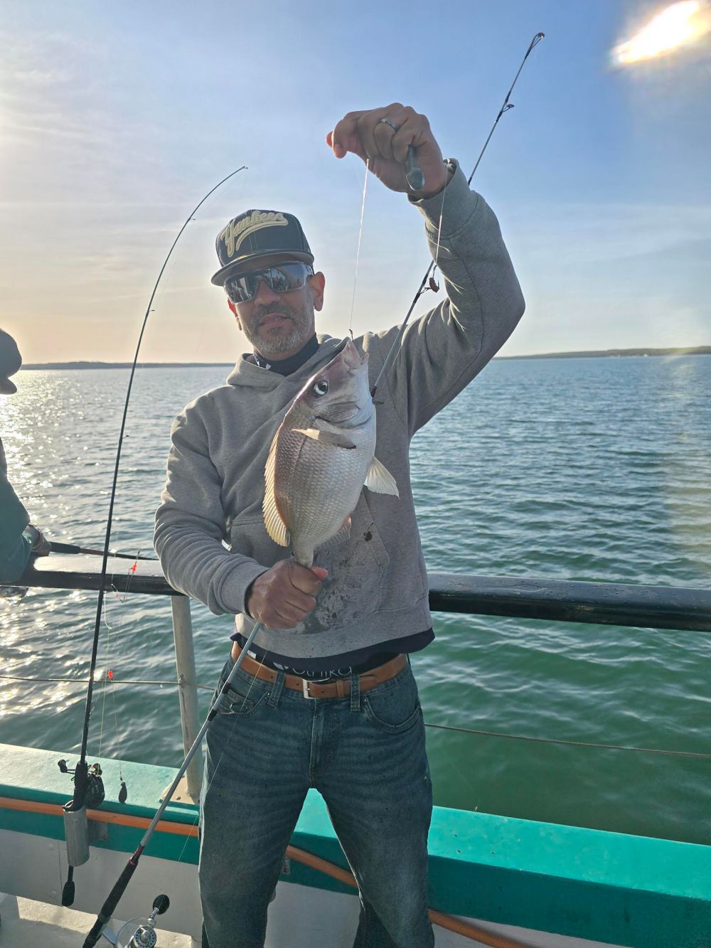 a man holding a fish on a boat
