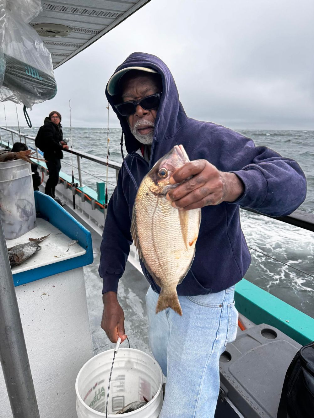 a person holding a fish on a boat