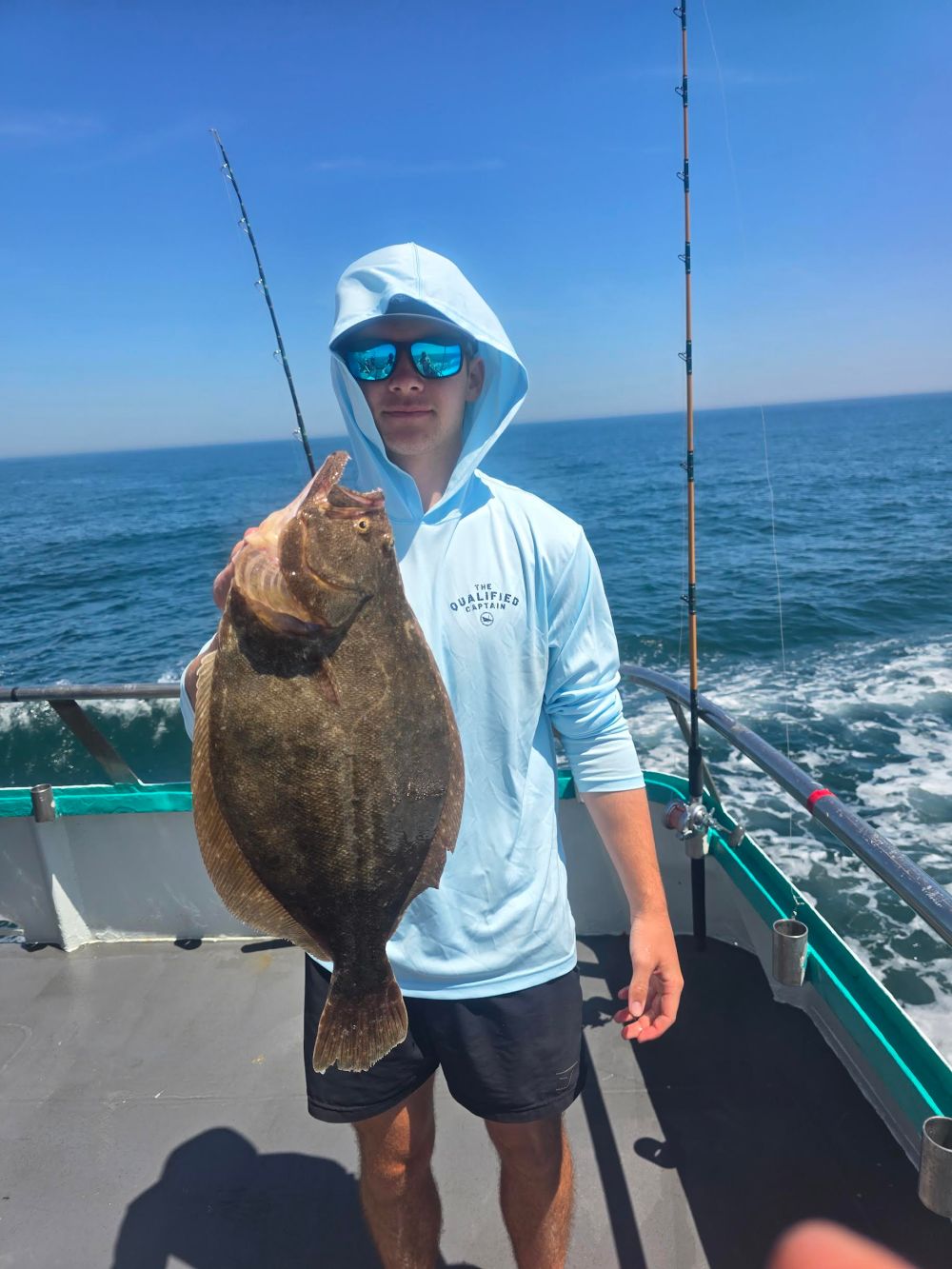 a person holding a fish on a boat in the water