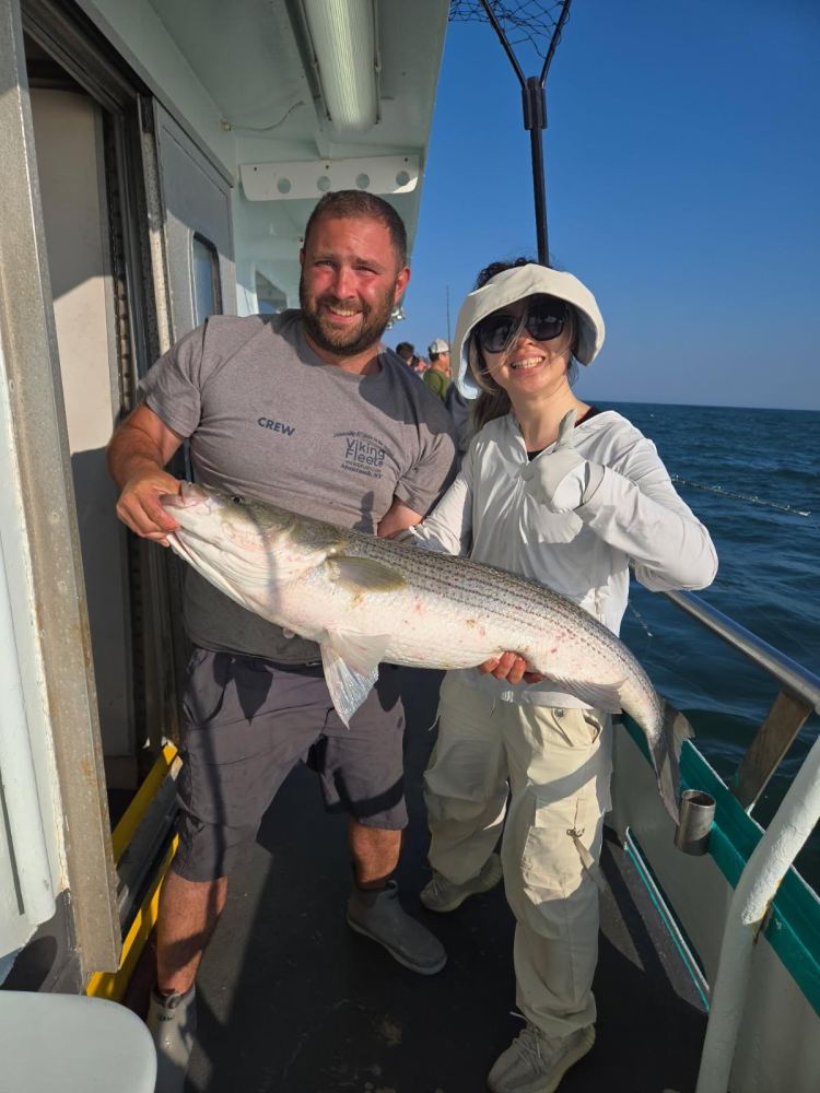 a man holding a fish on a boat