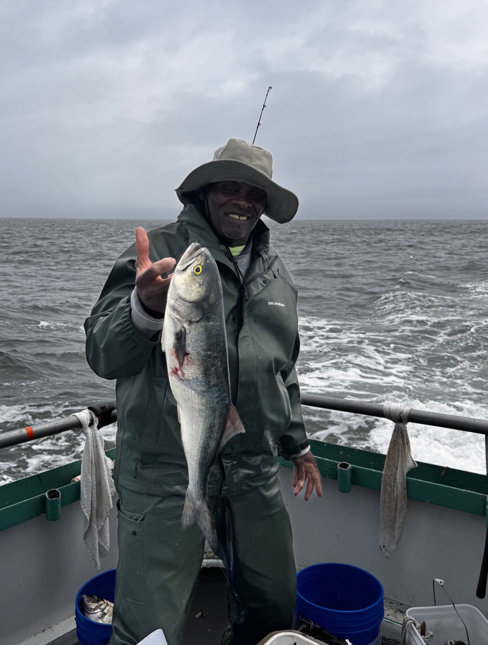 a person holding a fish on a boat in a body of water