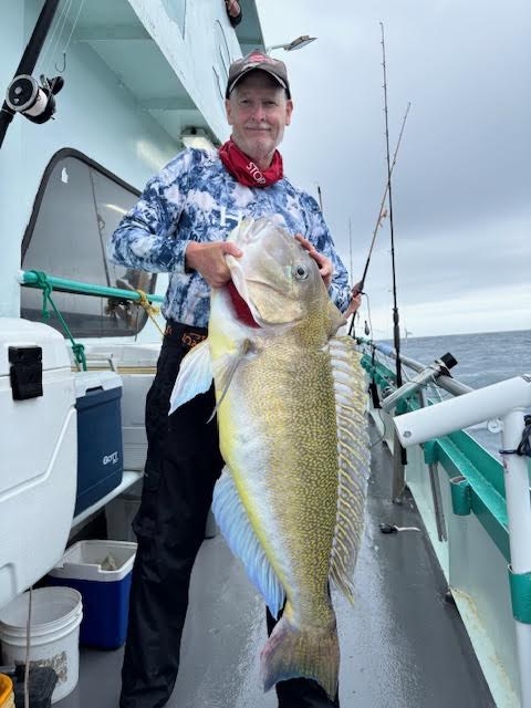 a man holding a fish on a boat