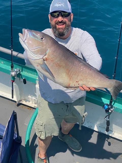 a man holding a fish on a boat