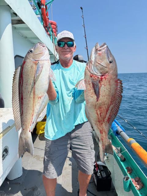 a person holding a fish on a boat