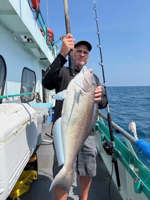 a person holding a fish on a boat