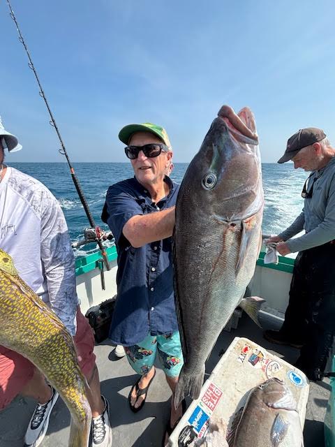 a man holding a fish in the water
