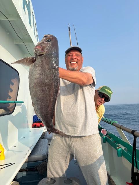 a man holding a fish on a boat