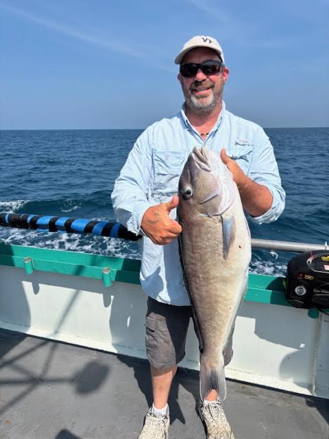 a man holding a fish in the water