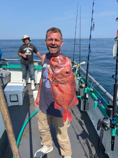 a person holding a fish on a boat