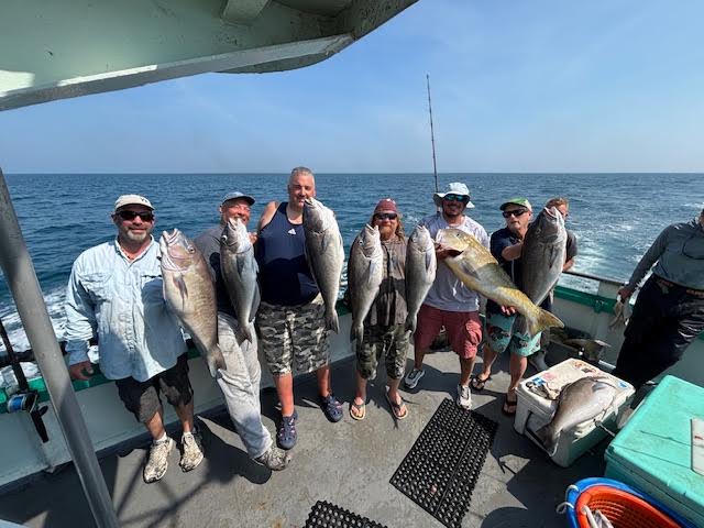 a group of people standing next to a body of water