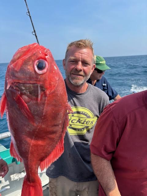 a man holding a fish in the water