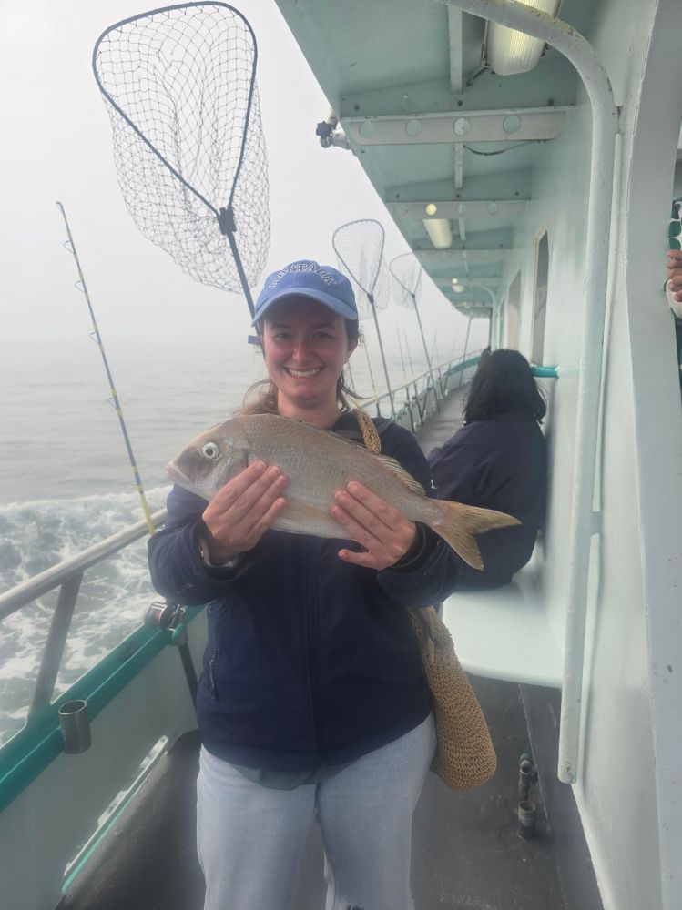 a person holding a fish on a boat