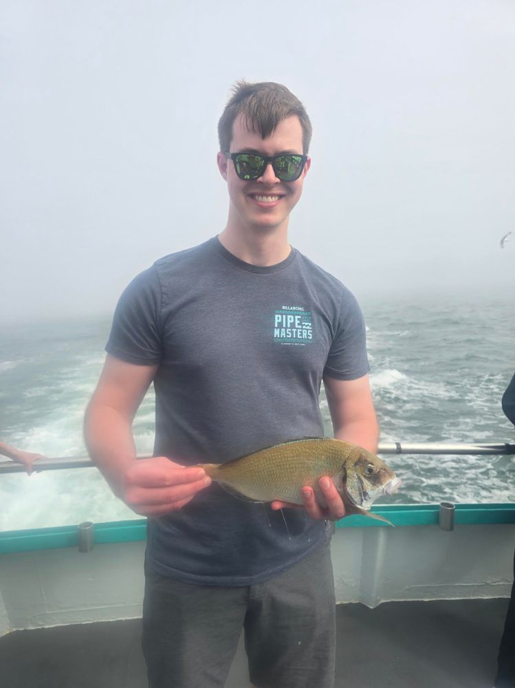 a man holding a fish in the water