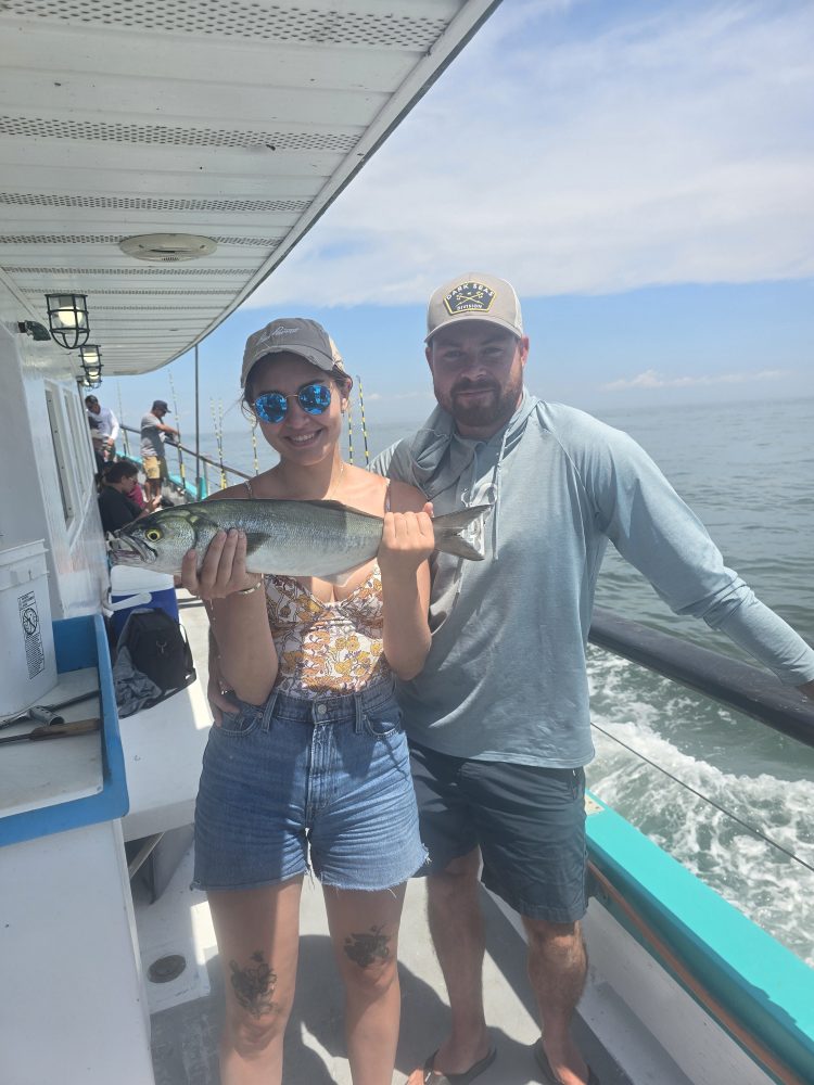 a man holding a fish on a boat