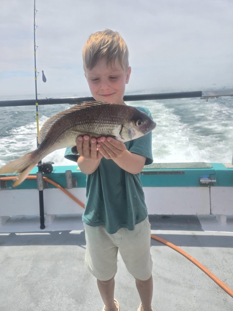 a young boy holding a fish