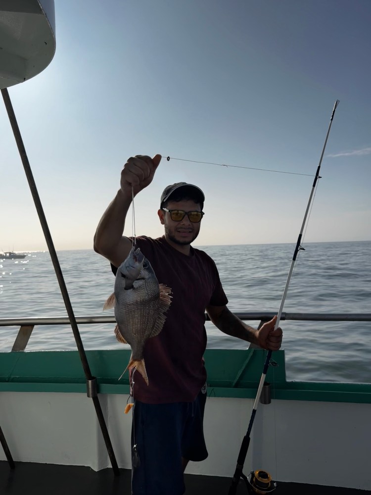 a man standing next to a body of water