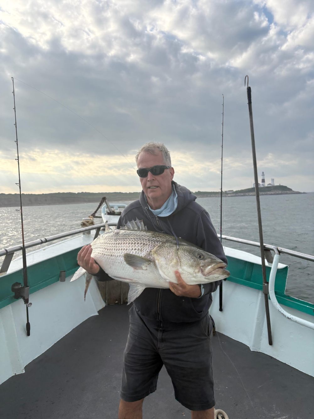 a man holding a fish on a boat