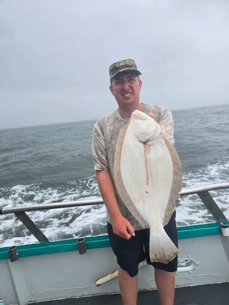 a man standing next to a body of water