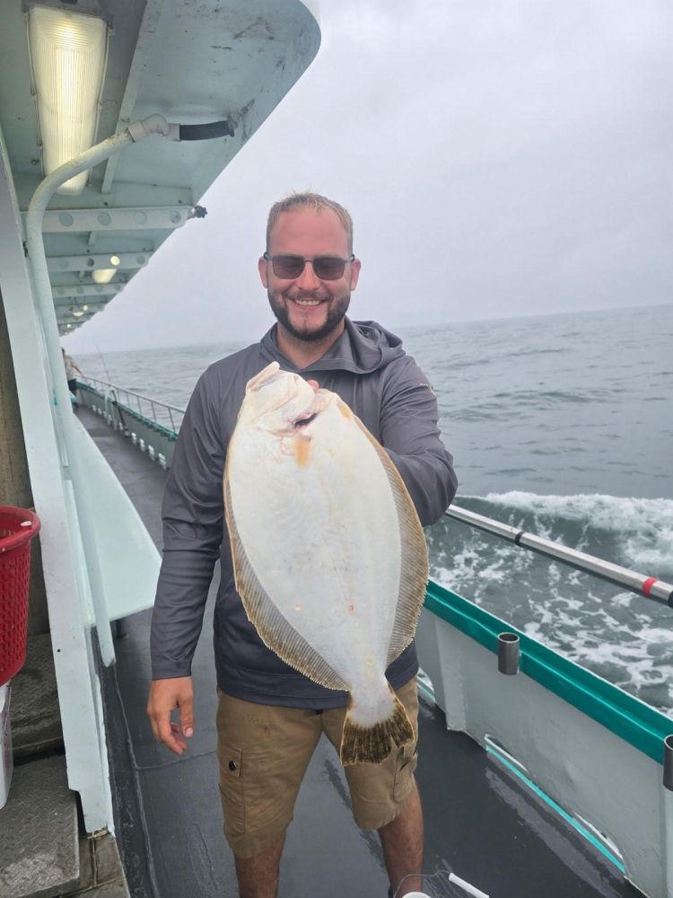 a man holding a fish on a boat