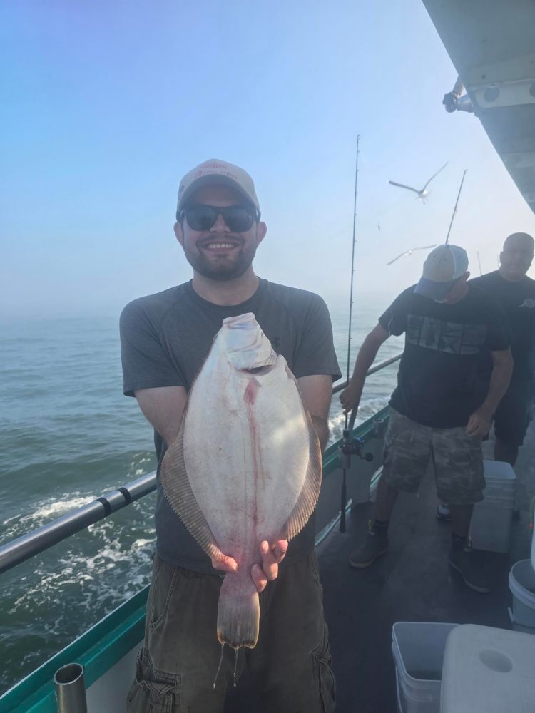 a man holding a fish on a boat