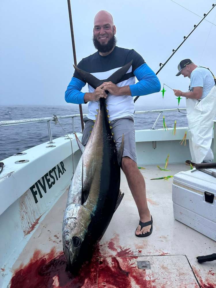 a person holding a fish on a boat