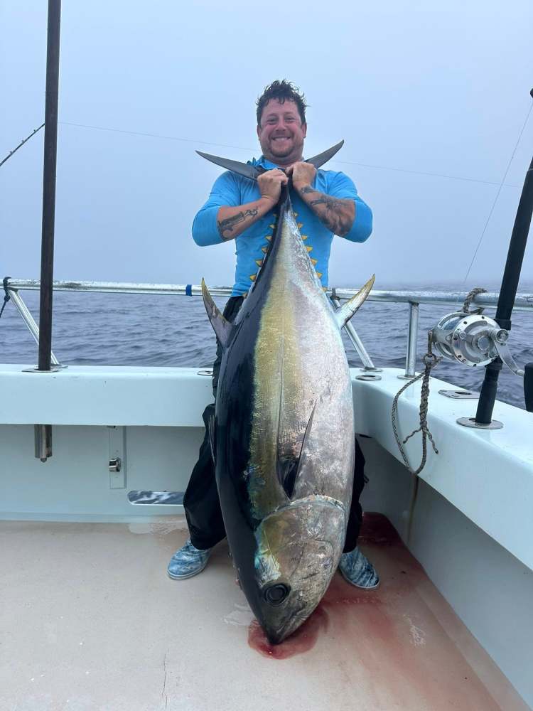 a person holding a fish on a boat