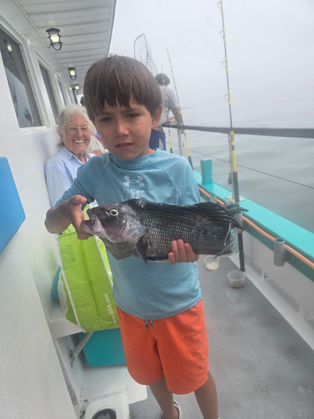 a young boy holding a fish
