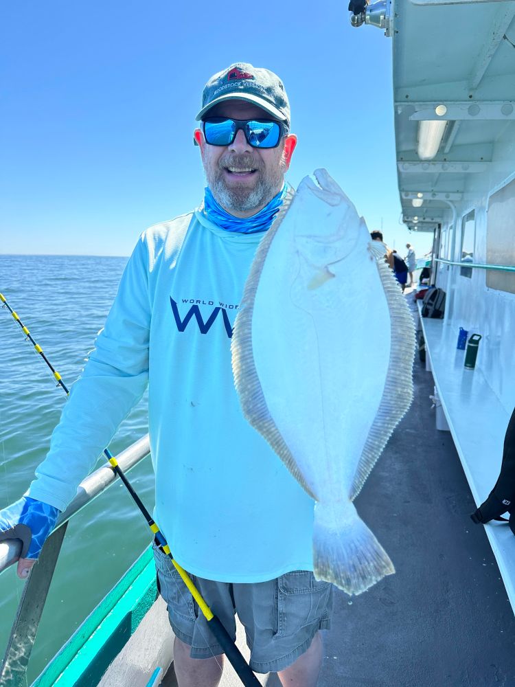 a man holding a fish on a boat in the water