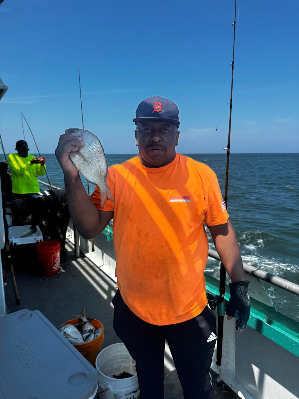 a man holding a fish on a boat in the water