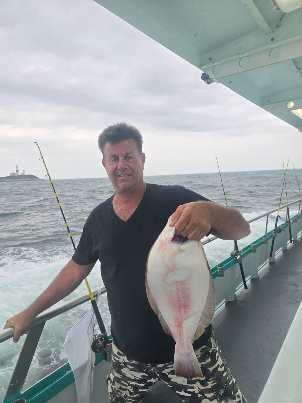 a man holding a fish on a boat