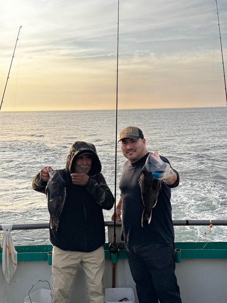 a group of people standing next to a body of water