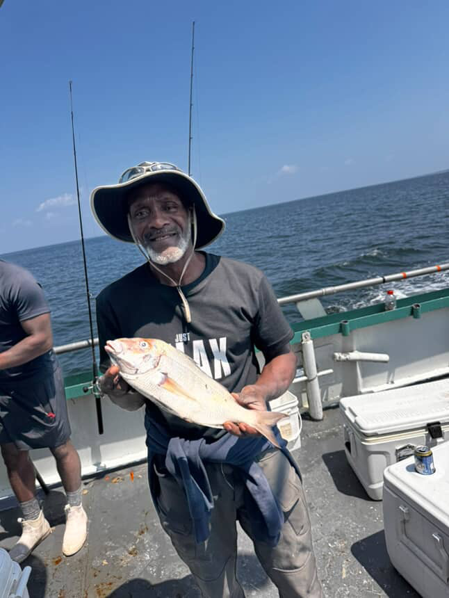 a person holding a fish on a boat