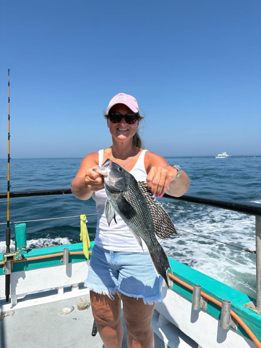 a man holding a fish on a boat in the water