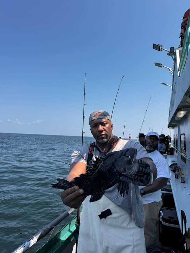 a man standing next to a body of water