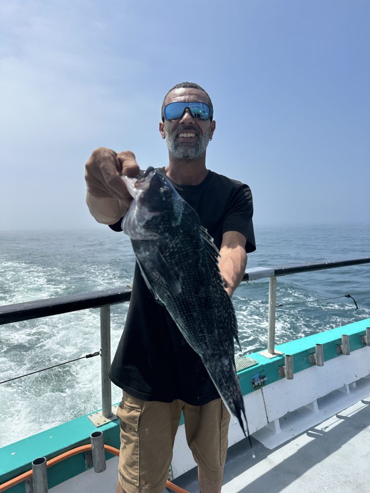 a man standing next to a body of water