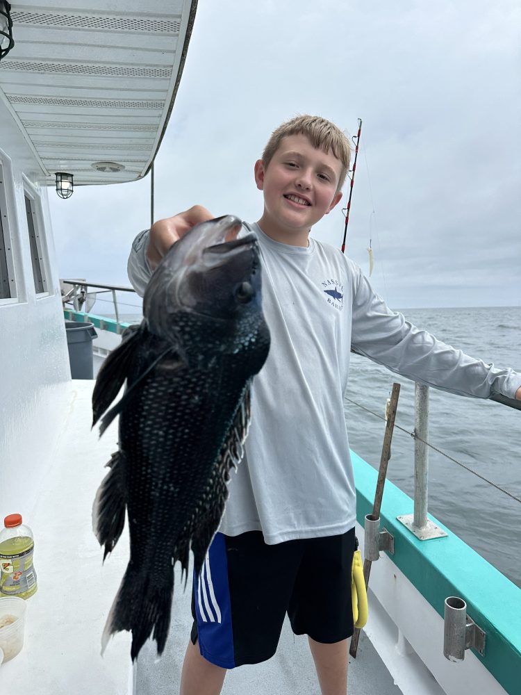 a person holding a fish on a boat