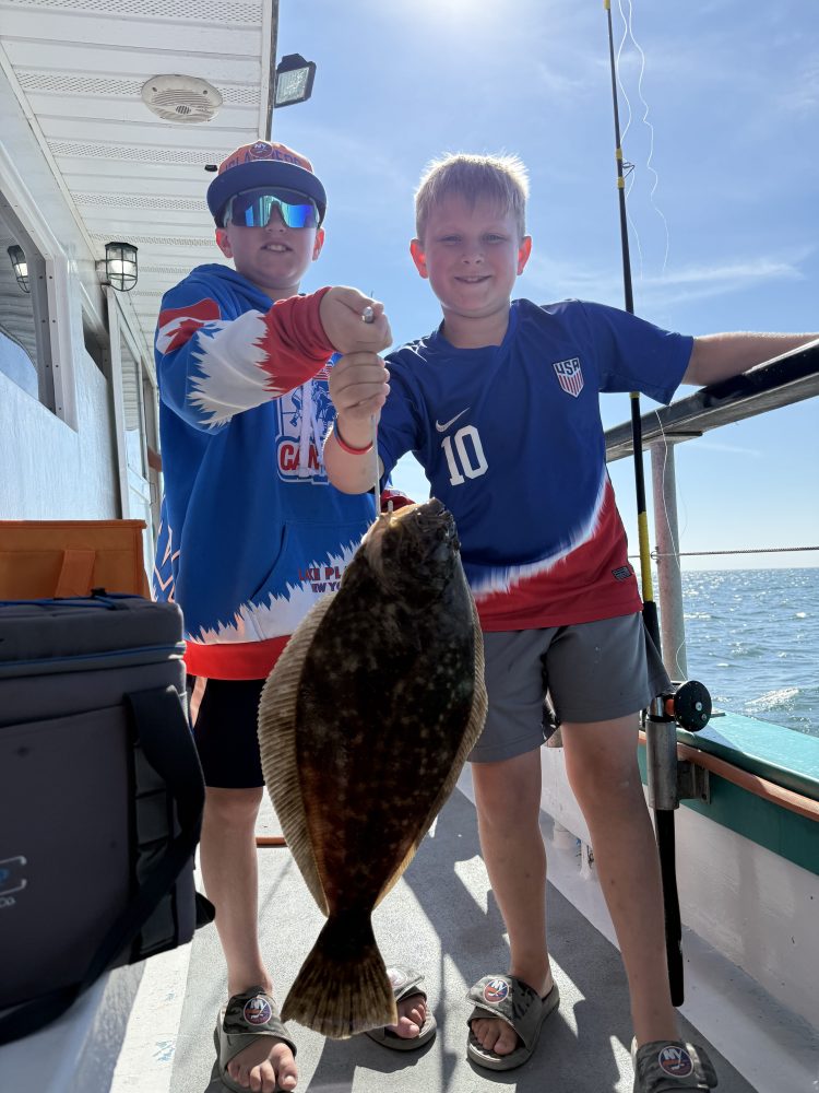 a young boy holding a fish