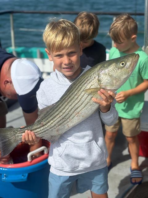 a young boy holding a fish