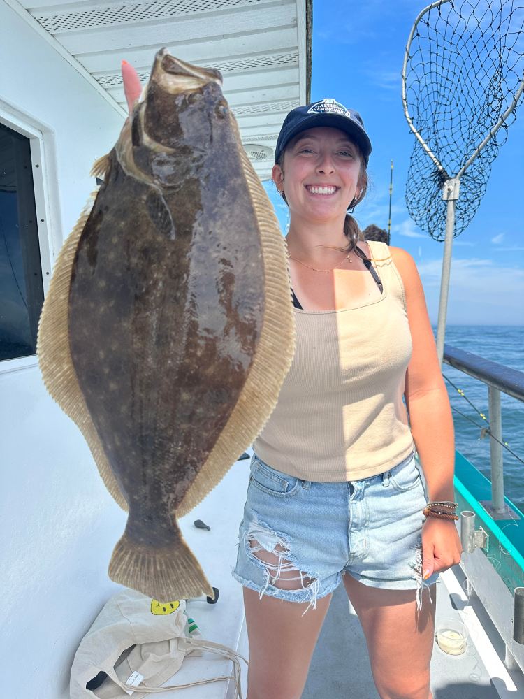 a person holding a fish posing for the camera