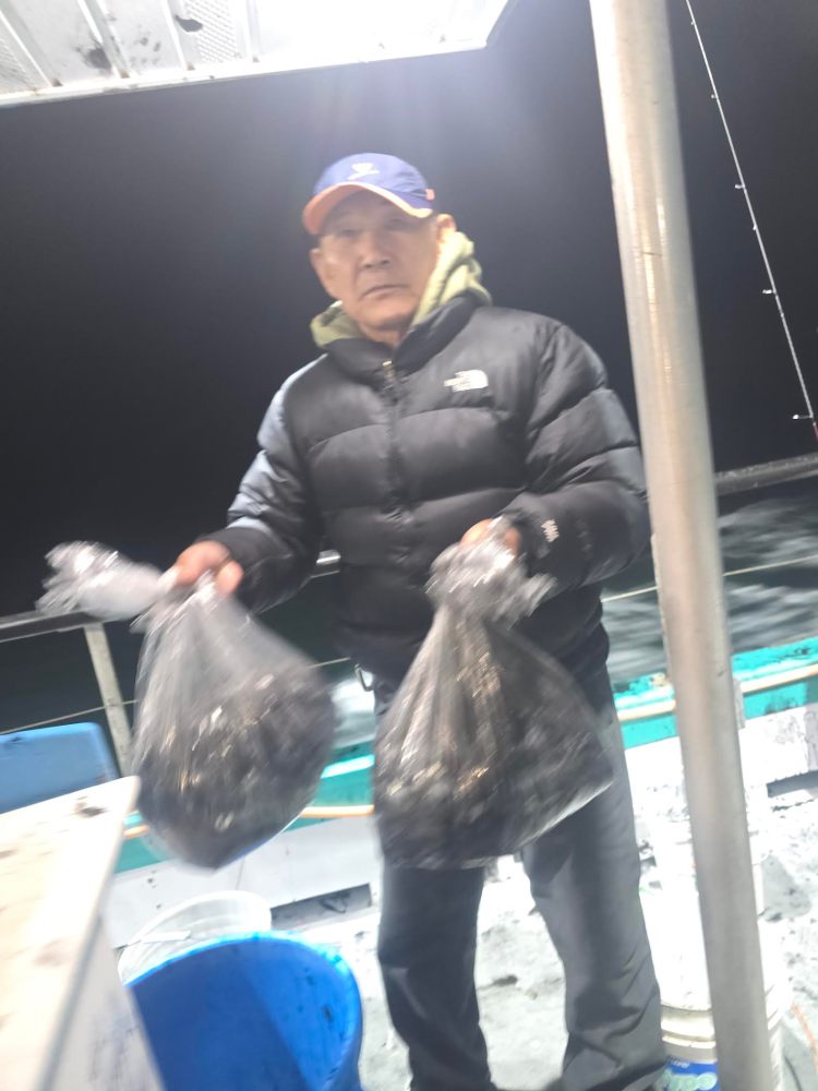 Person on a boat holding two bags, photographed at night.
