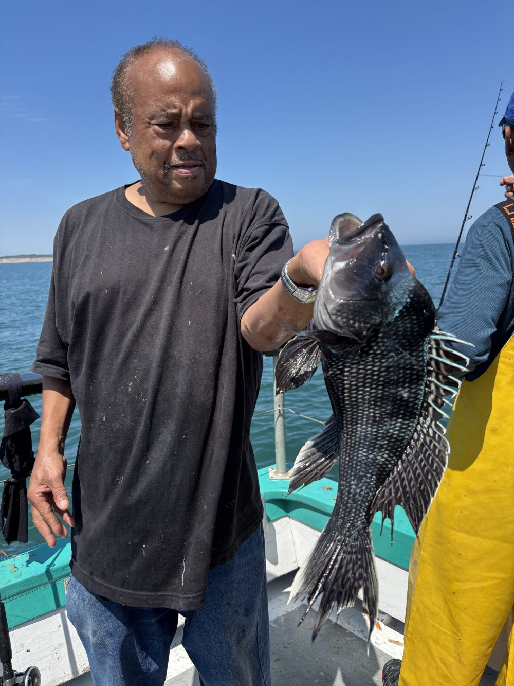 Person on a boat holding a large fish with spiky fins.