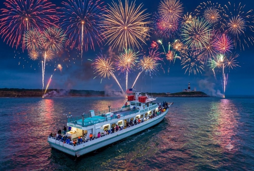 Boat on water with colorful fireworks in the sky at dusk.
