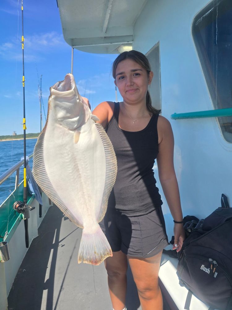 Person holding a large fish on a boat.
