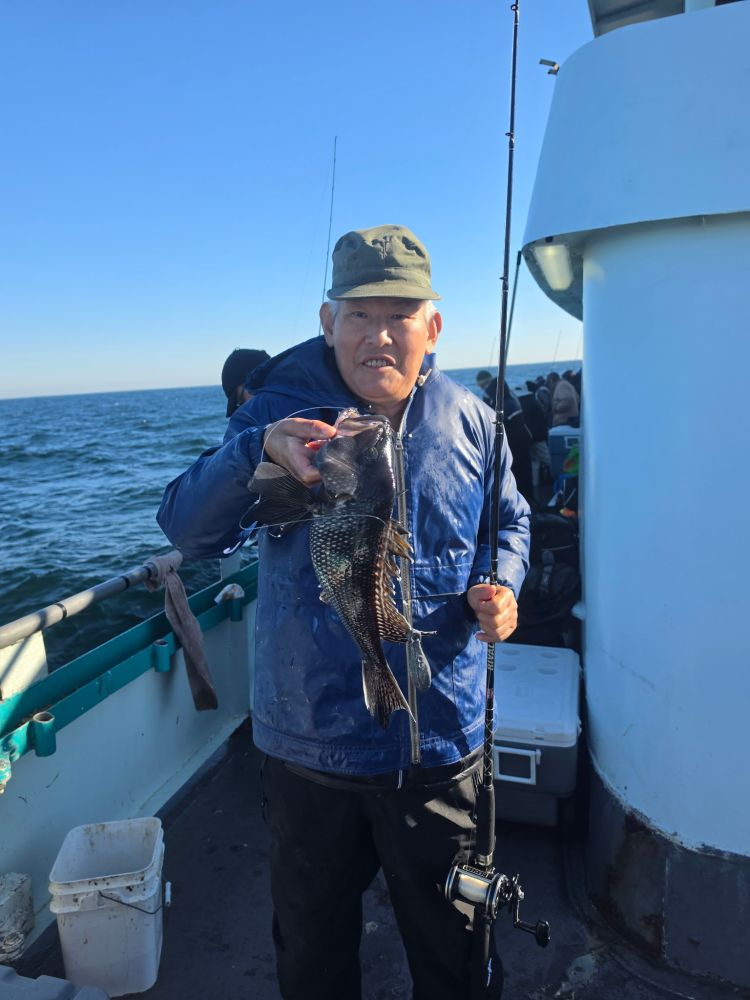 Person on boat holding fishing rod and caught fish.