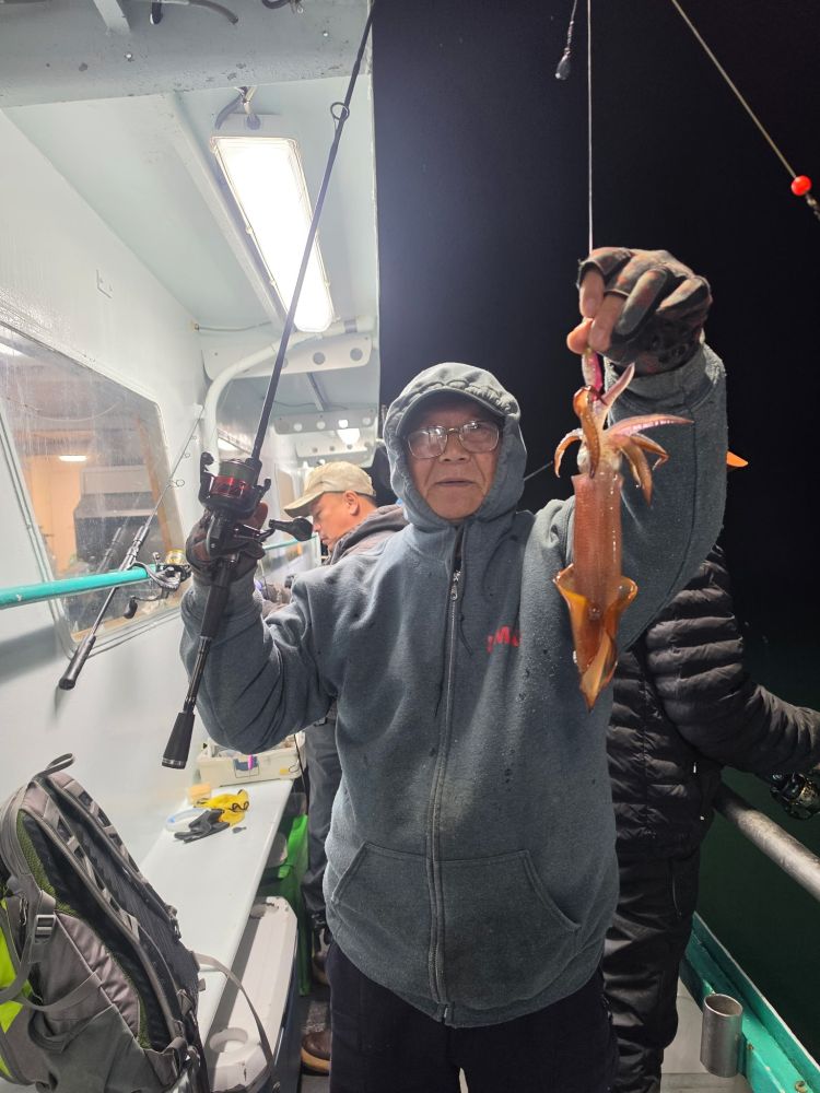 Person on a boat holding a squid with a fishing rod.